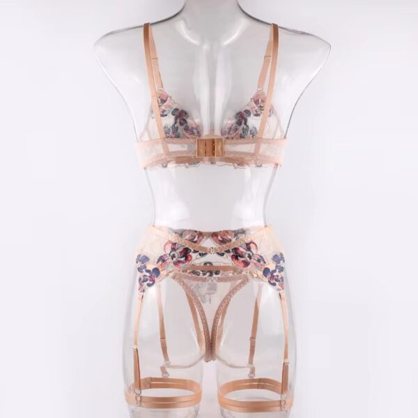 Full view of a floral embroidered lingerie set with cream trim, featuring a bra, thong, garter belt, and garters for a soft and elegant look.