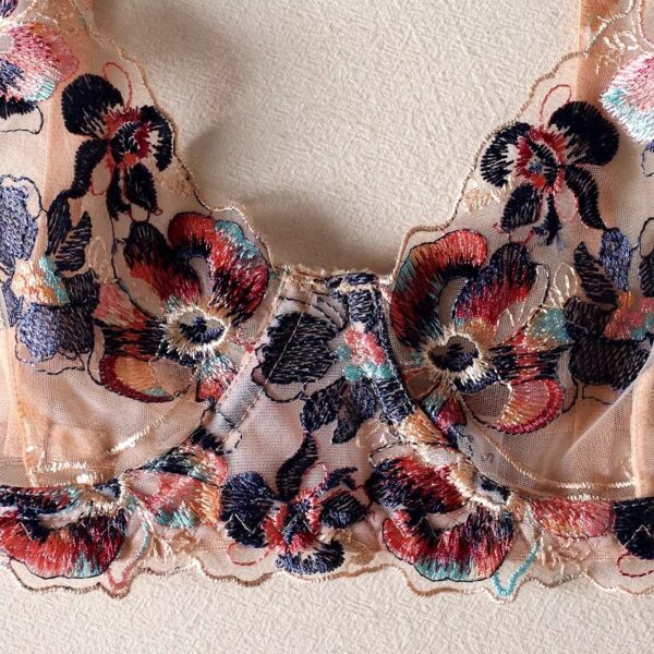 Close-up of the floral embroidery on the cream-colored bra from the lingerie set, highlighting the intricate and elegant design.