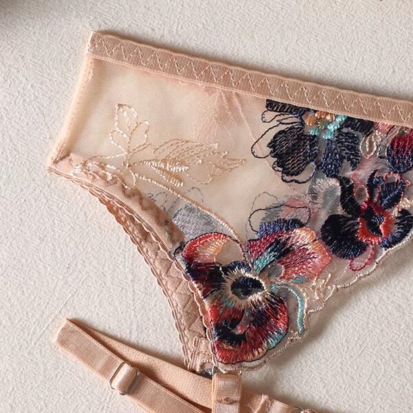 Close-up of the cream-colored garter belt from a floral embroidered lingerie set, showcasing the intricate details and feminine design.