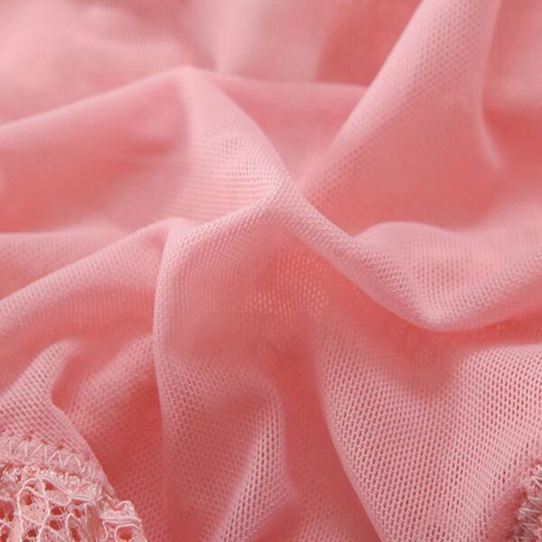 Close-up of the pink fabric of the bodysuit, showcasing its soft and romantic texture.