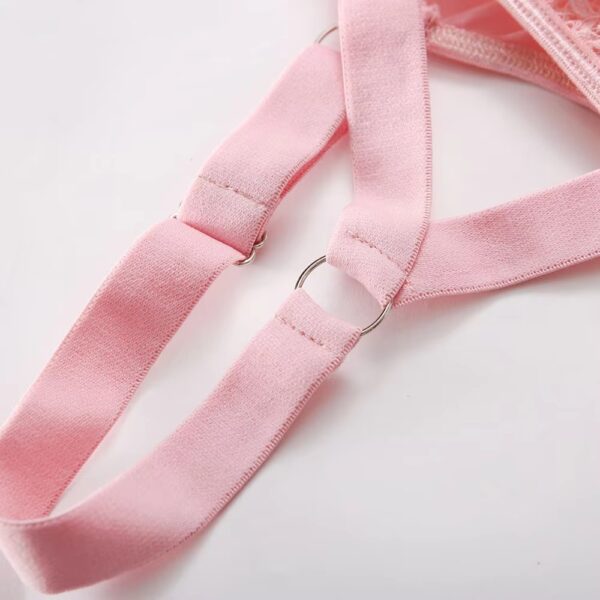 Close-up of the pink garter, showing its fine design and romantic details in a delicate lingerie set.