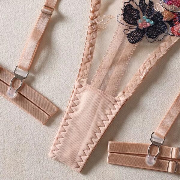 Close-up of the cream-colored thong and garters from a floral embroidered lingerie set, showcasing the delicate design and sensual details.